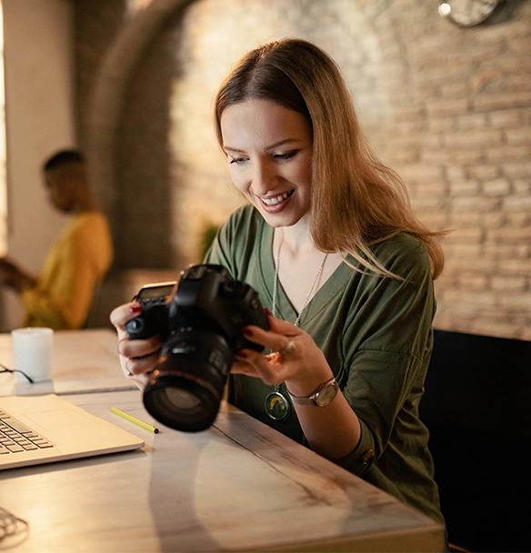 A female photographer looking at her photos in a coffee shop.