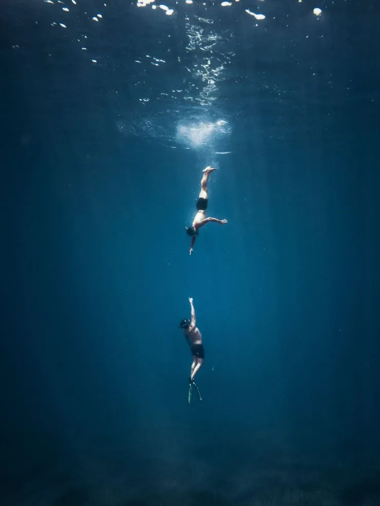 Two people free diving in the ocean