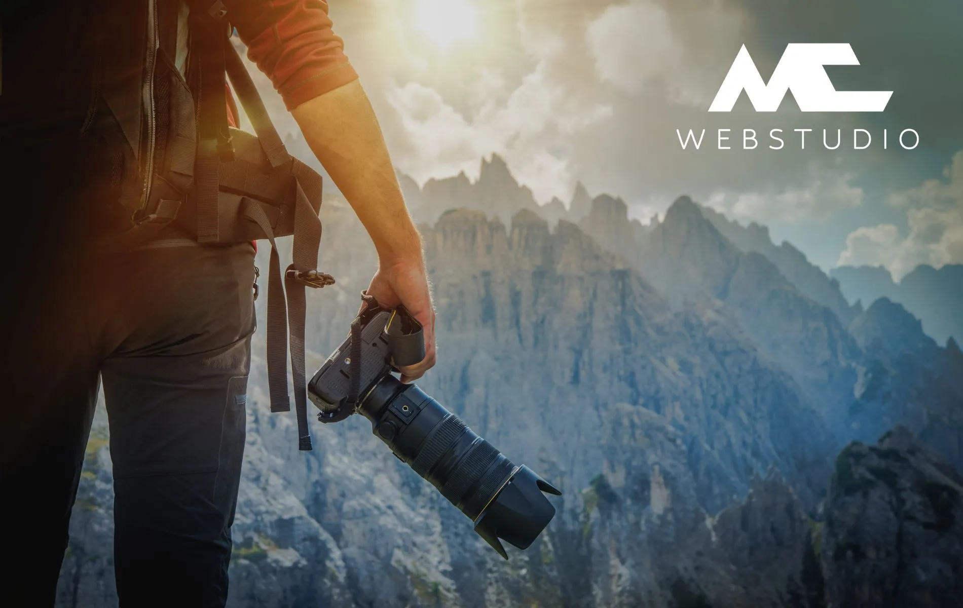 A photographer standing and looking at mountains.